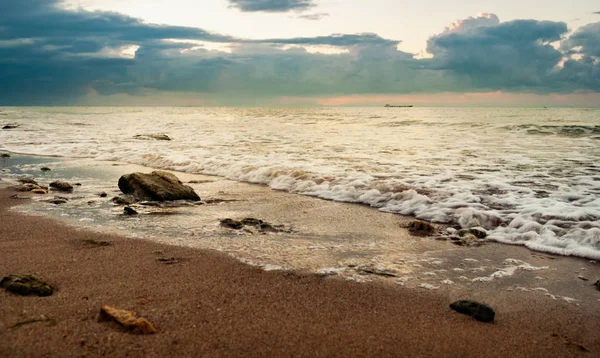 Piaszczysta plaża z kamieniami wczesnym rankiem — Zdjęcie stockowe