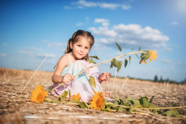 Nettes Kleines Mädchen Einer Langen Uniform Und Mit Sonnenblumen Sitzt — Stockfoto
