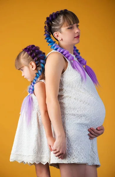 Красивая маленькая девочка и беременная мать — стоковое фото