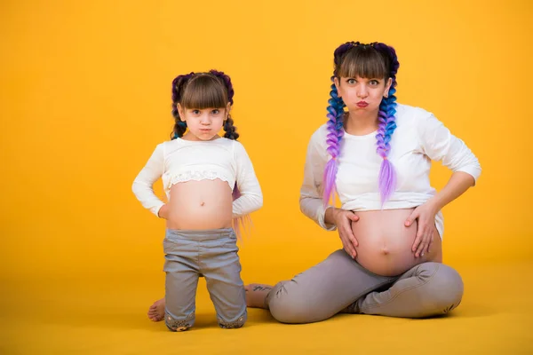 Mom and daughter show their pregnant belly — 스톡 사진