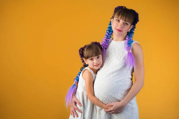 Encantadora chica escucha a las madres embarazadas vientre — Foto de Stock