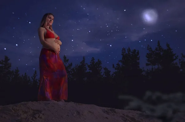 Wanita hamil cantik santai di luar di malam hari — Stok Foto