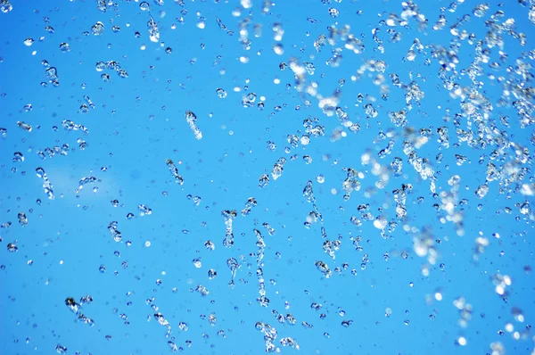 Blaue Wassertropfen auf blauem Himmel Hintergrund — Stockfoto