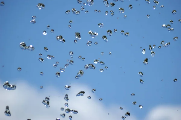 Gotas de água azul no fundo do céu azul — Fotografia de Stock