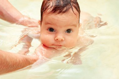 Küçük sevimli kız ılık suda banyo yapıyor.