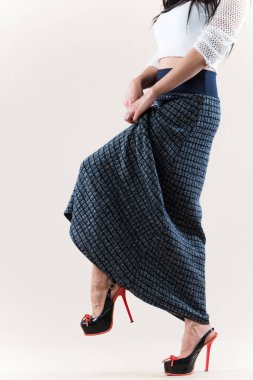 Kısa beyaz kazaklı, kimliği belirsiz genç bir kadın.