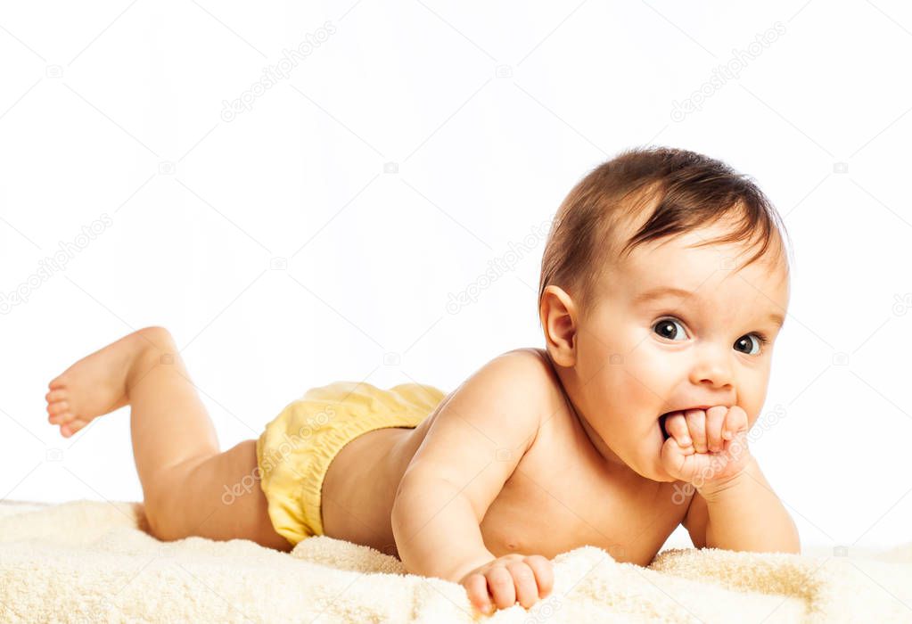 Charming little smiling girl lies on her stomach