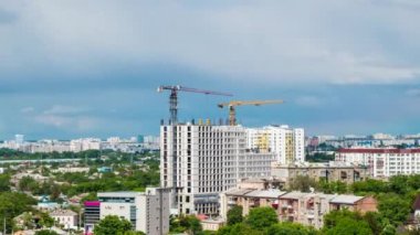 Şehrin zaman atlaması, büyük kule vinçleri çok katlı binalar inşa ediyor. UHD 4K videosu