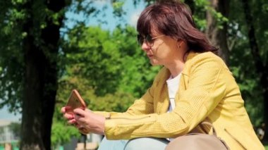 Bir kadın, sosyal ağlar için akıllı telefondan özçekim fotoğrafları çekiyor..