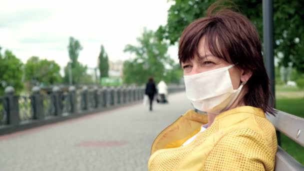 Πορτρέτο του λυπημένος αγνώστων στοιχείων γυναίκα ποζάρουν στο δρόμο σε προστατευτική λευκή ιατρική μάσκα — Αρχείο Βίντεο