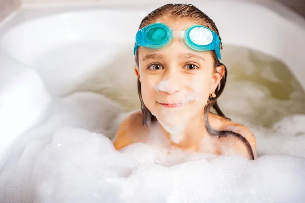 海でリラックスするのを待っている間 水泳ゴーグルを着用し 泡でお風呂で遊ぶ面白い小さな肯定的な白人の女の子 子供のための衛生とホームエンターテイメントの概念 — ストック写真