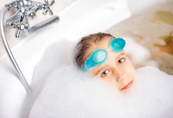 海でリラックスするのを待っている間 水泳ゴーグルを着用し 泡でお風呂で遊ぶ面白い小さな肯定的な白人の女の子 子供のための衛生とホームエンターテイメントの概念 — ストック写真