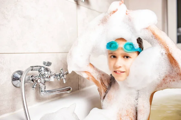 Yüzme gözlüklü güzel mavi gözlü küçük kız evde Coronavirus sırasında köpük banyosunda banyo yapıyor. Ev kavramında Chidrens oyunları