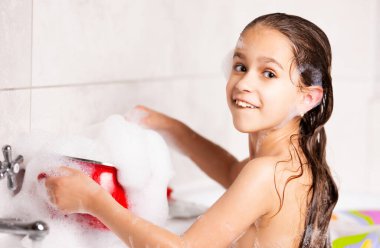 Neşeli küçük beyaz kız karantina sırasında küvette banyo yaparken köpükle oynuyor. Komik çocuklar Coronavirus sırasında evde eğlenirler. Kopyalama alanı
