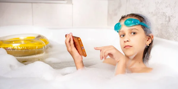 Vtipná Malá Běloška Plaveckých Brýlích Surfuje Internetu Pomocí Smartphonu Při — Stock fotografie