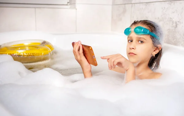 Lustiges Kleines Kaukasisches Mädchen Mit Schwimmbrille Surft Mit Dem Smartphone — Stockfoto