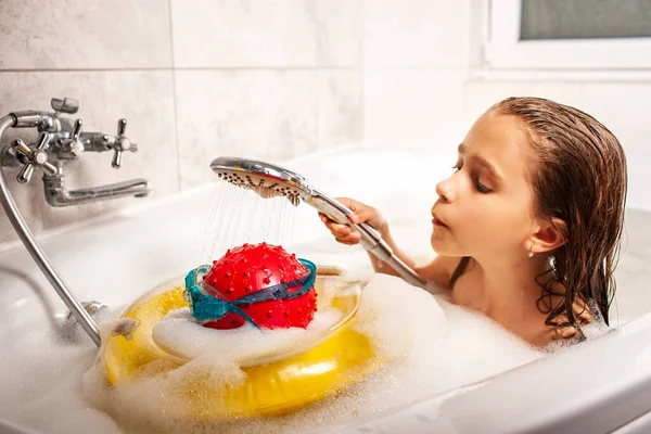 집에서 목욕중에 공으로 머리를 두르고 샤워실 수영용 고글을 던지고 여자아이 — 스톡 사진