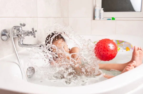 Маленькая Девочка Веселится Ванной Играет Надувной Красный Мяч Сидя Ванной — стоковое фото