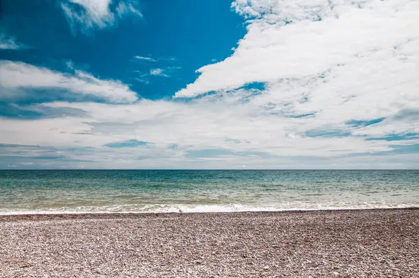 Wybrzeże Morskie Kamienista Plaża Błękitne Niebo Białymi Chmurami Góry Mała — Zdjęcie stockowe