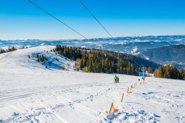 Büyüleyici füniküler yol dağların, karlı tepelerin ve soğuk kış akşamlarında mavi gökyüzünde pitoresk bir yerde. Avrupa ülkelerinde kış turizmi kavramı. Reklam alanı
