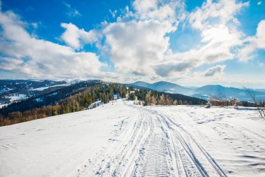 Güneşli bir kış gününde kar altında ATV ve kayak izleri. Avrupa 'daki kış dağlarında rahatlama kavramı. Reklam alanı