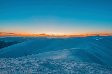 Gecenin ilerleyen saatlerinde karlı vadideki dağların ve tepelerin büyüleyici manzarası. Kış kırsal ve kış hafta sonu rahatlama güzellik konsepti. Kopyalama alanı