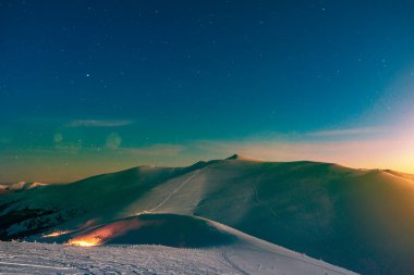 Akşamüstü güneş battıktan sonra kayak merkezindeki yamaçların muhteşem manzarası. Tatillerde ve yeni yıl tatillerinde kuzeyde tatil kavramı.
