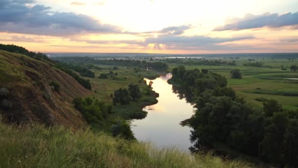 Panoramiczny widok rzeki między polami podczas zachodu słońca. — Wideo stockowe