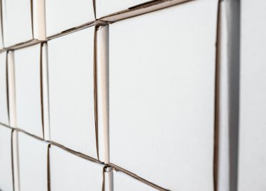 Beyaz kağıt kutuların yan görünüşü, minimalist tasarım nesneleri. Doğumhanede karton şekilli boş paketler olan duvar, yakın görüş, insan yok..