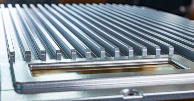 Fabrikadaki tanımlanamayan otomatik kontrol cihazının kontrol panelinin yanındaki flütlü metal yüzeye yakın çekim. Gizli askeri üretim kavramı