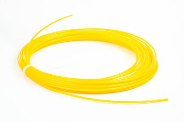 Sarı rulo ipliğin üst görüntüsü 3D kalem PLA beyaz üzerinde izole. Kapalı alanda yatan 3D yazıcı için plastik parlak kablo. Çocuk eğlencesi ve yaratıcılığı kavramı.
