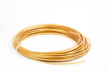 Altın sarısı ipliğin üst görüntüsü 3 boyutlu kalem PLA beyaz üzerine izole edildi. Kapalı alanda yatan 3D yazıcı için plastik parlak kablo. Çocuk eğlencesi ve yaratıcılığı kavramı.