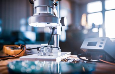 Büyük modern elektron mikroskobu. Mikrodalga eş eksenli konnektör ve atölye masasında elektronik çoklu metre. Bilimsel bir laboratuvarda yüksek frekanslı radyo elektronik bileşenleri araştırması.