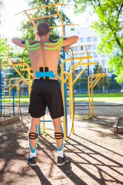 Açık havada elastik iplerle tanınmayan erkek sporcu eğitimi..