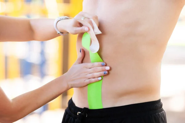 Kinesio tapes on the stomach of a young man — Stock Photo, Image
