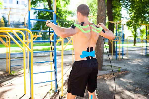 Açık havada elastik iplerle tanınmayan erkek sporcu eğitimi..