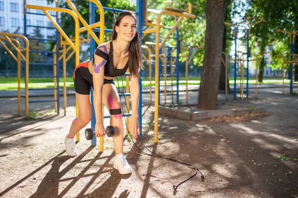 Atleta femenina con entrenamiento de cinta cinesiológica al aire libre. —  Fotos de Stock