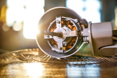 Evdeki soğutma vantilatörünün yakın çekimi önleyici temizlik, kayganlaştırma ve özel bir atölyede tamir sırasında bir masanın üzerinde yatar. Hasarlı ekipmanların onarımı ve restorasyonu