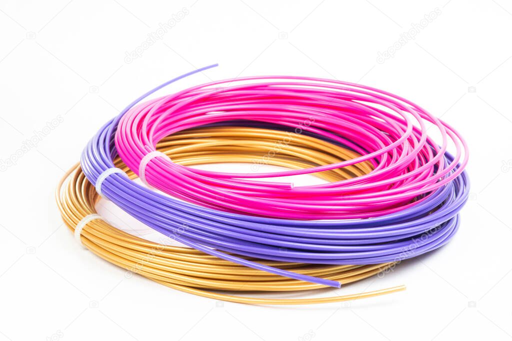 Top view of of three colorful rolled filament 3D pen PLA isolated on white. Closeup of plastic bright wires for 3D printer lying indoors. Concept of children's entertainment and creativity.