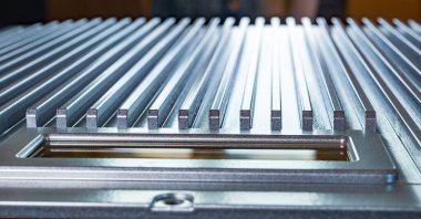 Fabrikadaki tanımlanamayan otomatik kontrol cihazının kontrol panelinin yanındaki flütlü metal yüzeye yakın çekim. Gizli askeri üretim kavramı