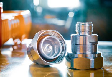 Mikrodalga eş eksenli adaptör 716 DIN Male to N Female Connector atölye masasında. Metalik kaplamalı yüksek frekans bileşeni