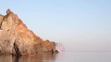 Rocky sahili sakin deniz dalgalarıyla yıkanır.