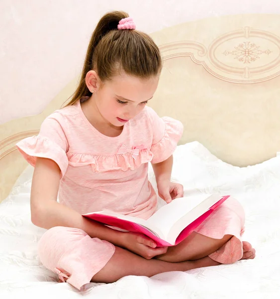 Entzückendes Kleines Mädchen Liest Ein Buch Auf Dem Bett — Stockfoto