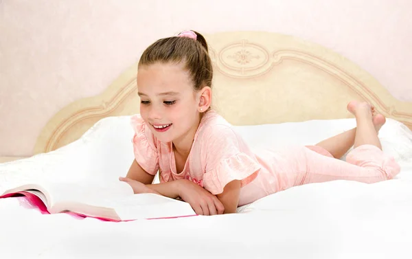 Sevimli Küçük Kız Çocuk Yatağın Üzerine Bir Kitap Okuyor — Stok fotoğraf