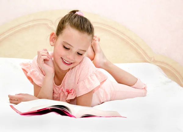 Entzückendes Kleines Mädchen Liest Ein Buch Auf Dem Bett — Stockfoto