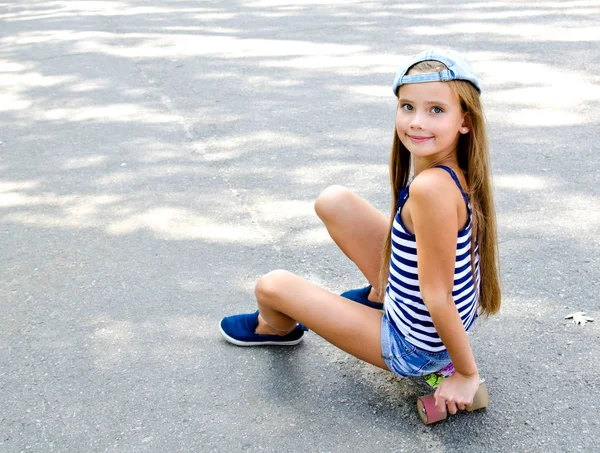 可爱的快乐微笑的小女孩与滑板户外在夏天的一天 — 图库照片