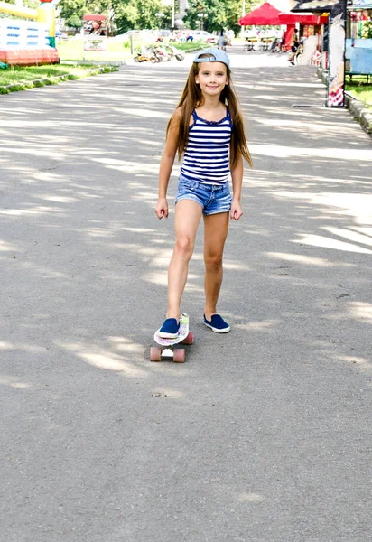 愛らしい幸せな笑みを浮かべて小さな女の子子夏の日の屋外のスケート ボードと — ストック写真