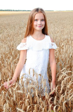 Sevimli küçük kız çocuğu buğday açık alan üzerinde gülümseyen