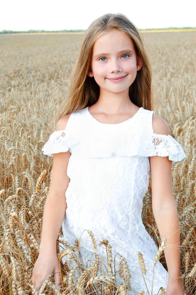屋外の小麦畑にかわいらしい女の子子供の笑顔 — ストック写真