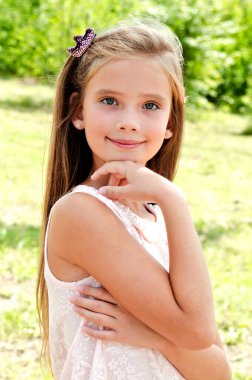 Açık havada yaz günü içinde gülümseyen sevimli küçük kız portresi